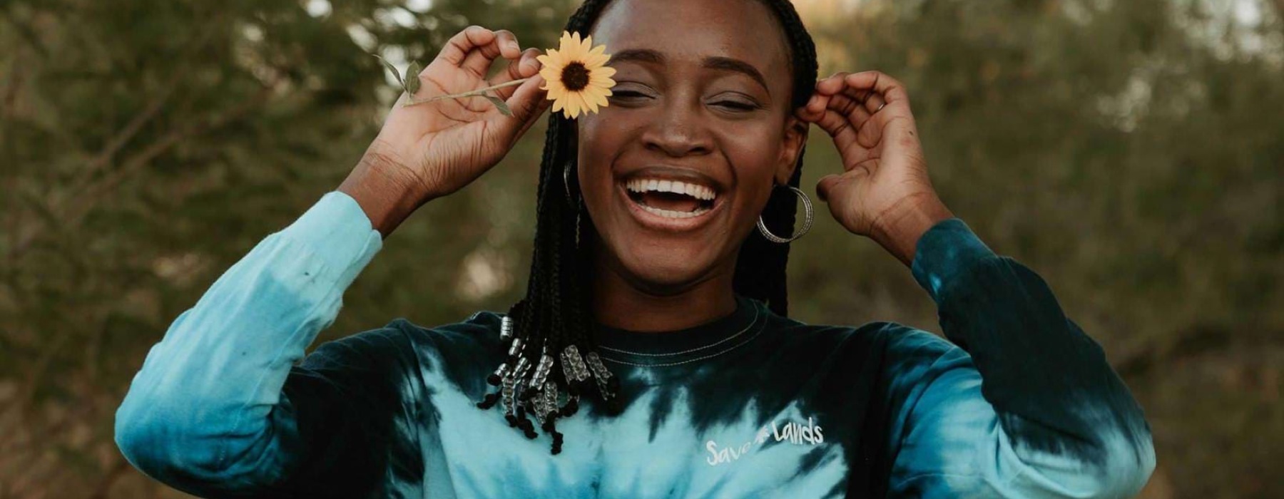 woman holds a flower in her hair in a park