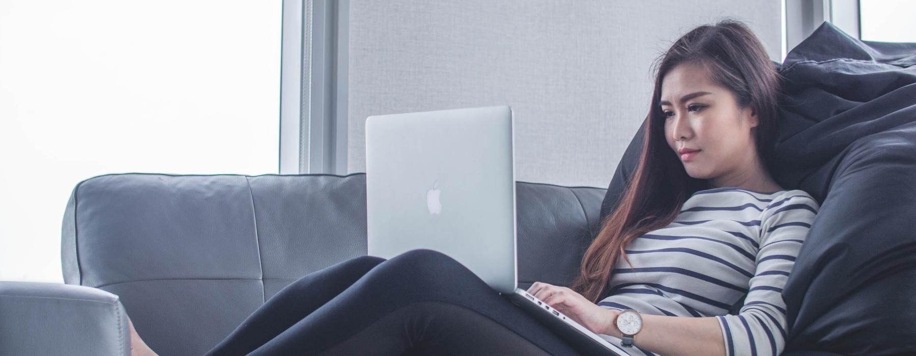 a person sitting on a couch with a laptop