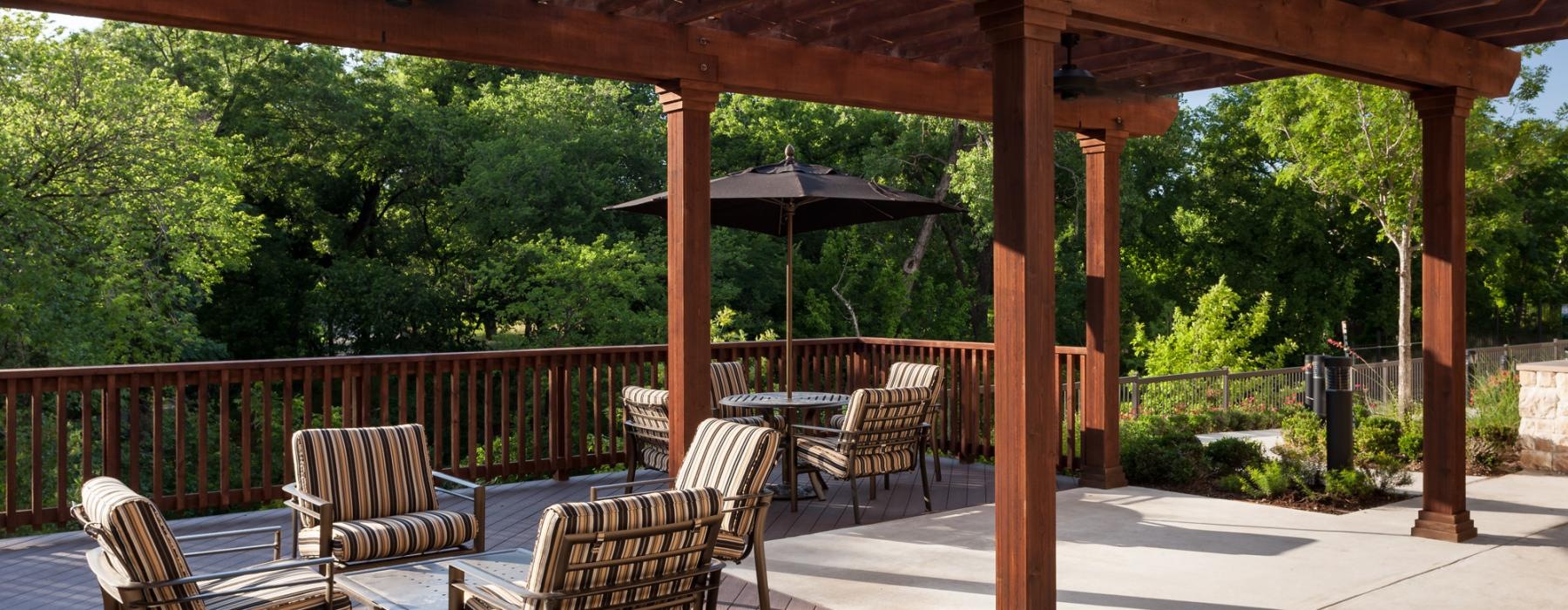 a patio with chairs and umbrella