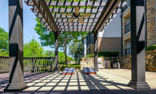 a covered area with a bench and a wooden structure